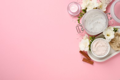 Flat lay composition with body scrubs on pink background, space for text