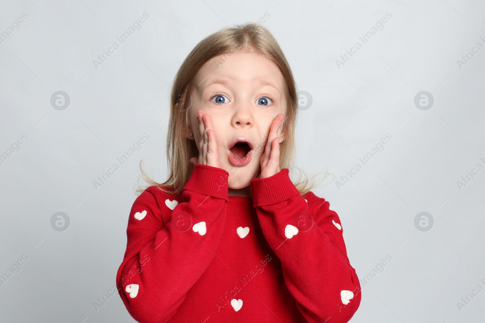 Photo of Portrait of cute emotional little girl on light grey background