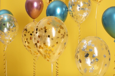 Photo of Bright balloons with ribbons on color background