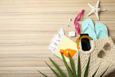Flat lay composition with smartphone and beach objects on wooden background. Space for text