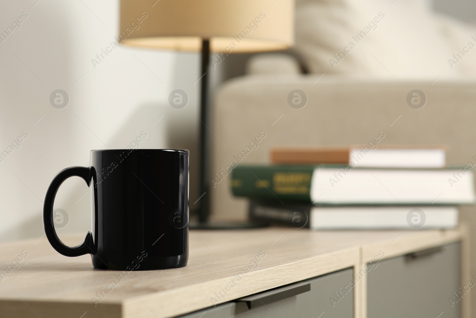 Photo of Black mug on wooden table indoors. Mockup for design