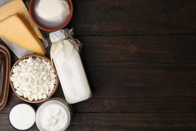 Different fresh dairy products on wooden table, top view. Space for text