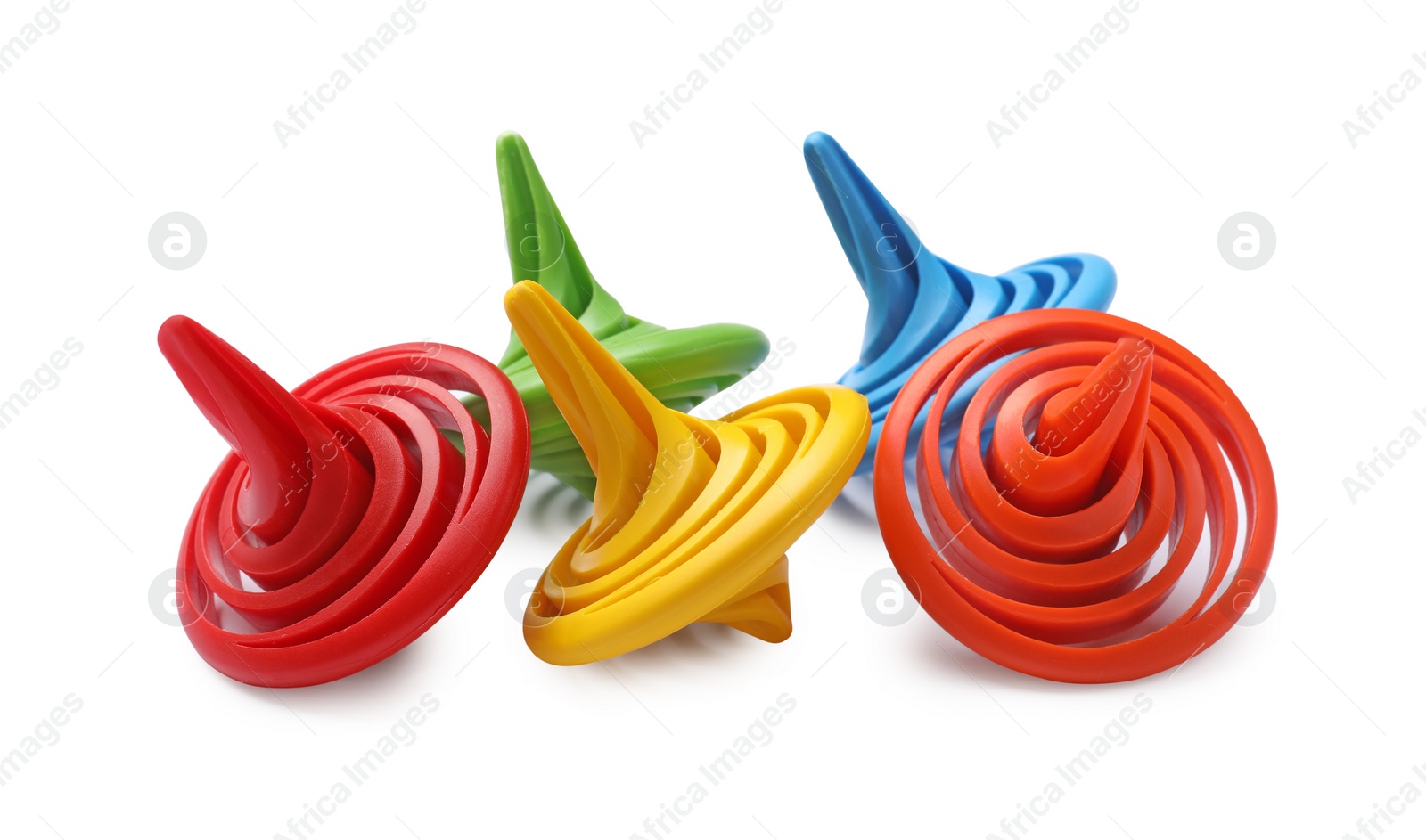 Photo of Many colorful spinning tops on white background