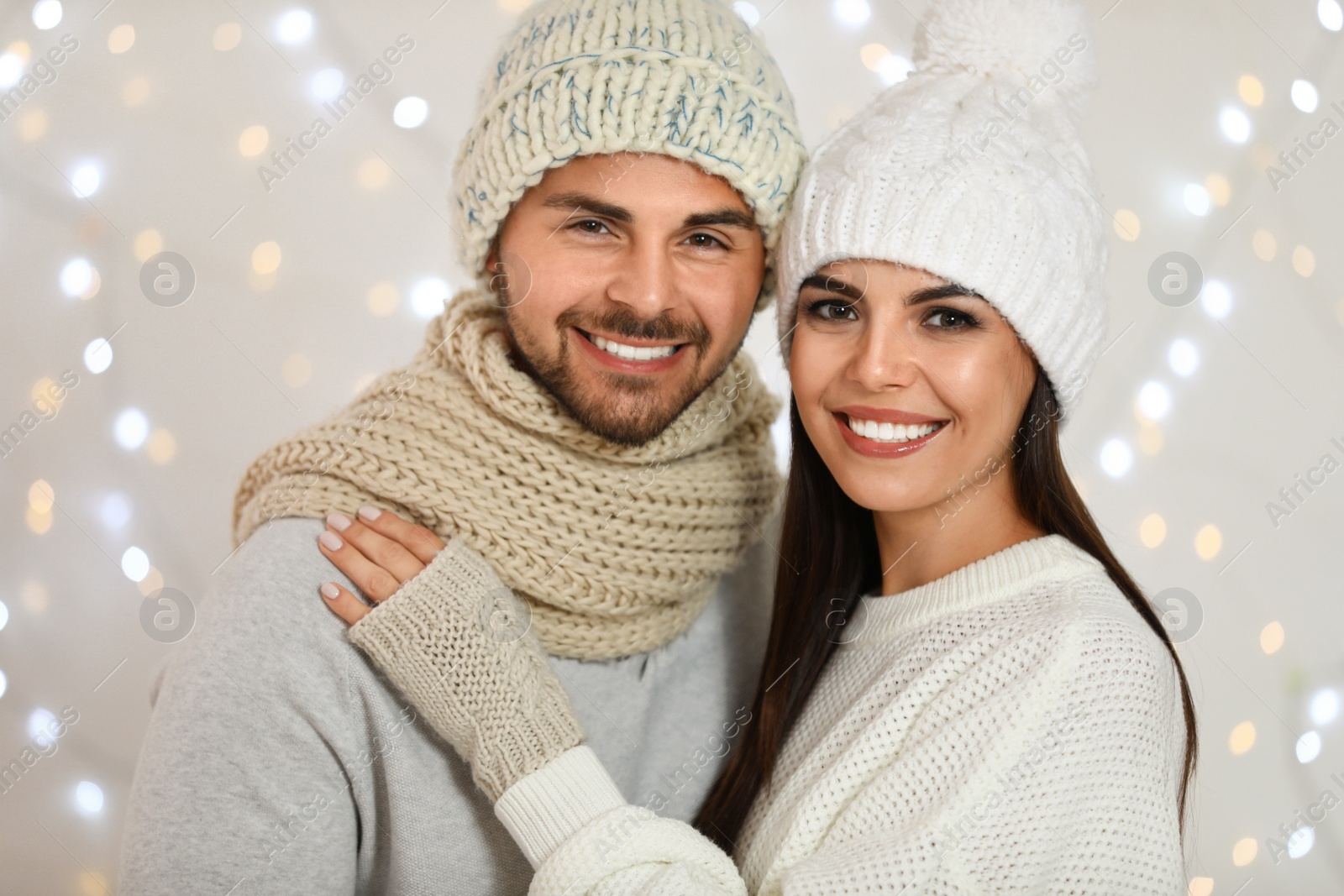 Photo of Lovely young couple against blurred festive lights. Christmas celebration