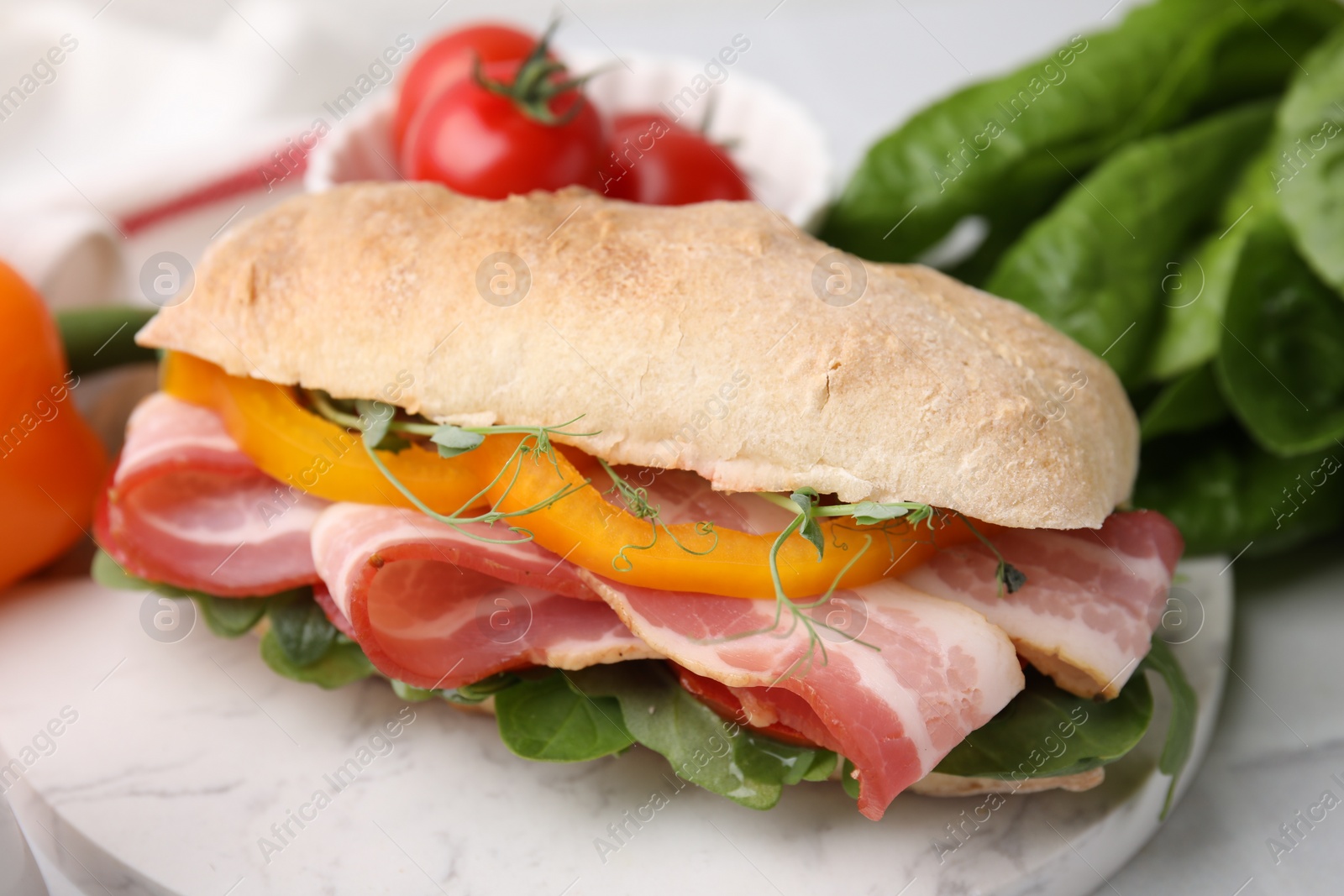 Photo of Tasty sandwich with bacon and bell pepper on white table, closeup