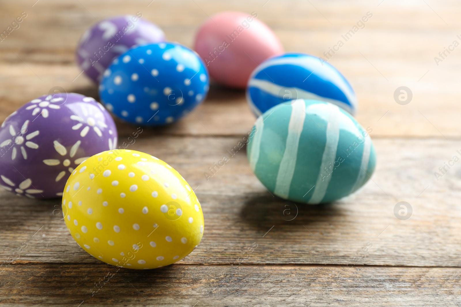 Photo of Painted Easter eggs on wooden table, space for text