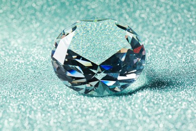 Beautiful dazzling diamond on shiny glitter background, closeup. Precious gemstone