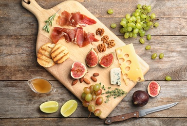 Flat lay composition with ripe figs and delicious products on wooden background