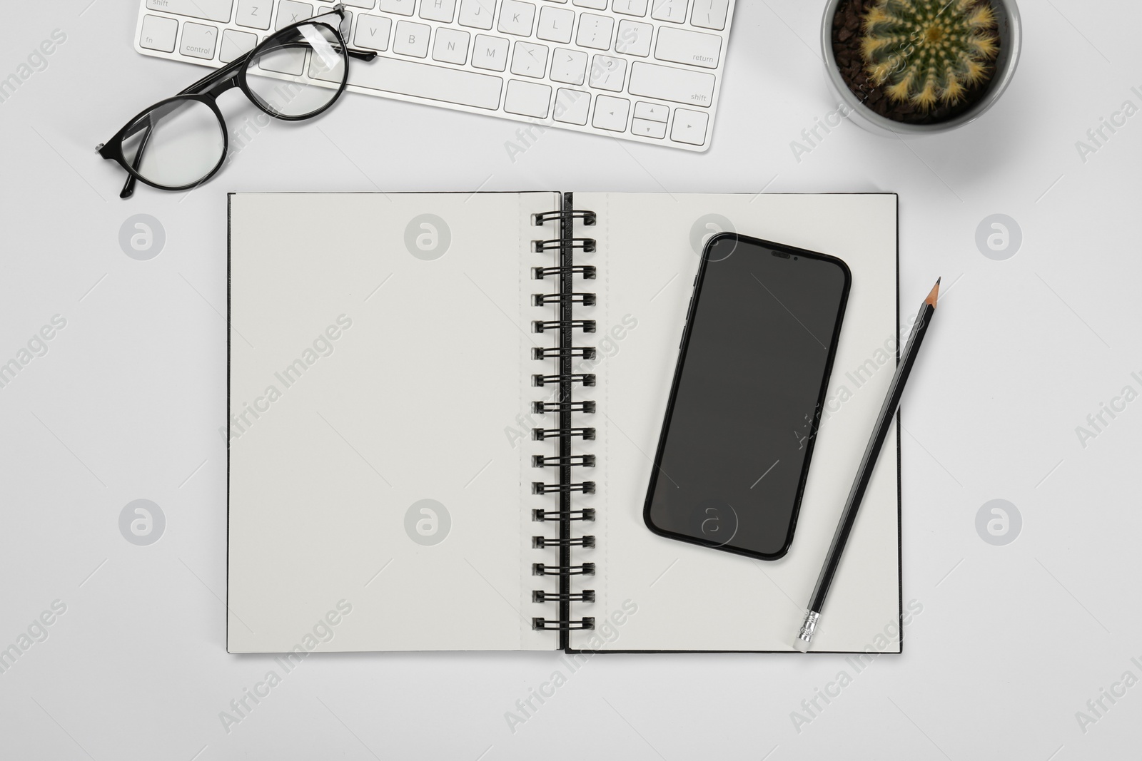 Photo of Flat lay composition with open notebook and smartphone on white table