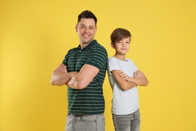 Portrait of dad and his son on color background