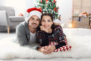 Photo of Happy young couple celebrating Christmas at home