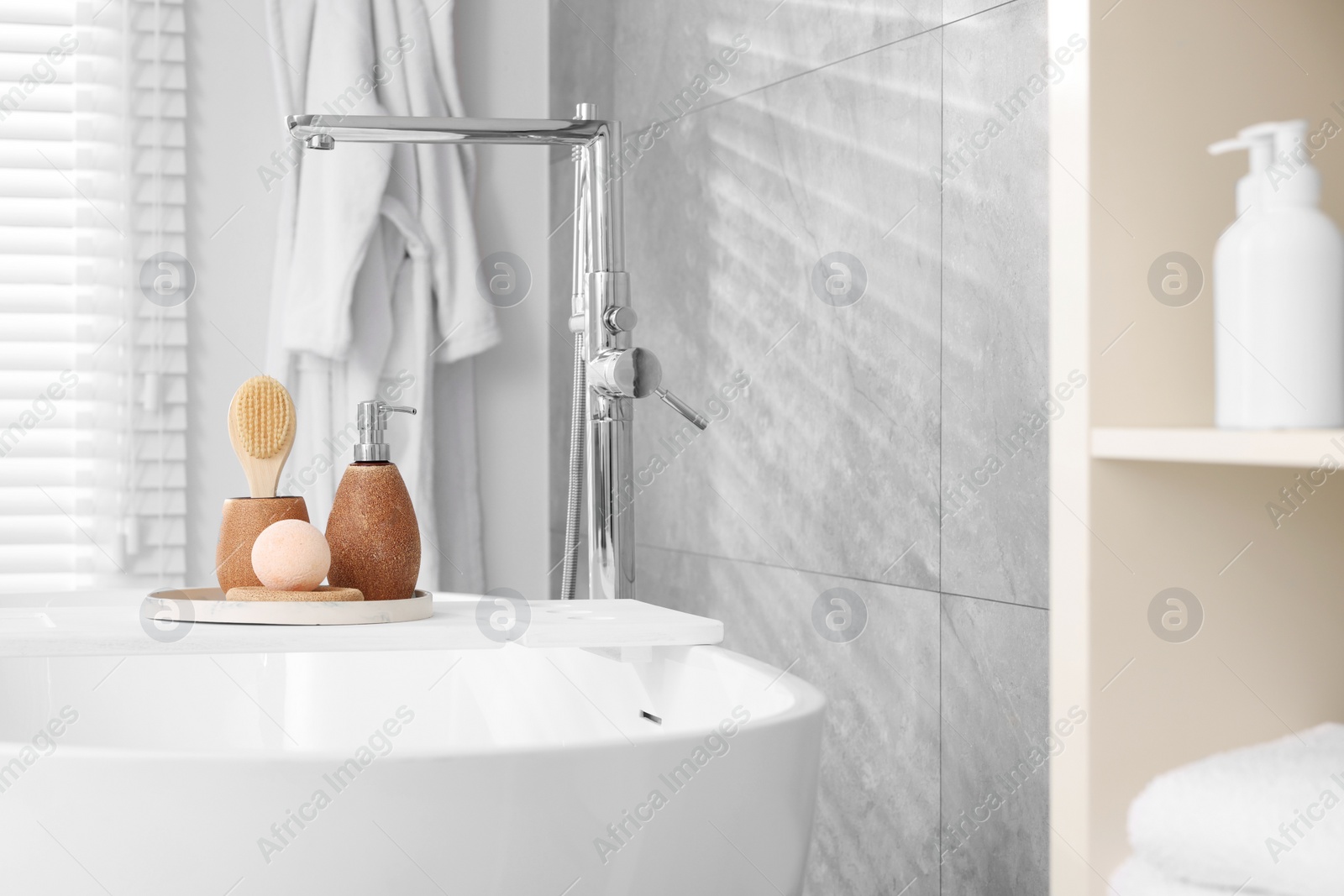 Photo of Different personal care products and accessories on bath tub in bathroom