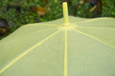 Photo of Closeup view of yellow umbrella with rain droplets outdoors