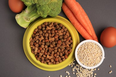 Photo of Dry pet food and products on black background, flat lay