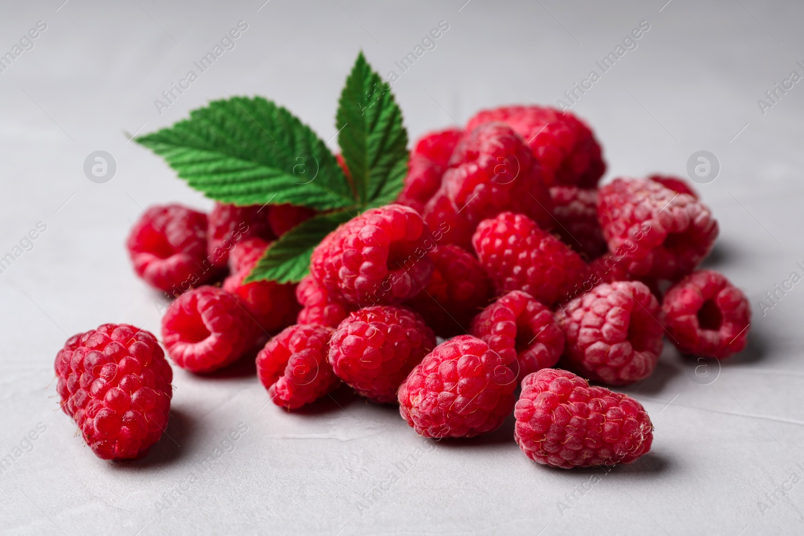 Photo of Heap of delicious ripe raspberries on light background, closeup