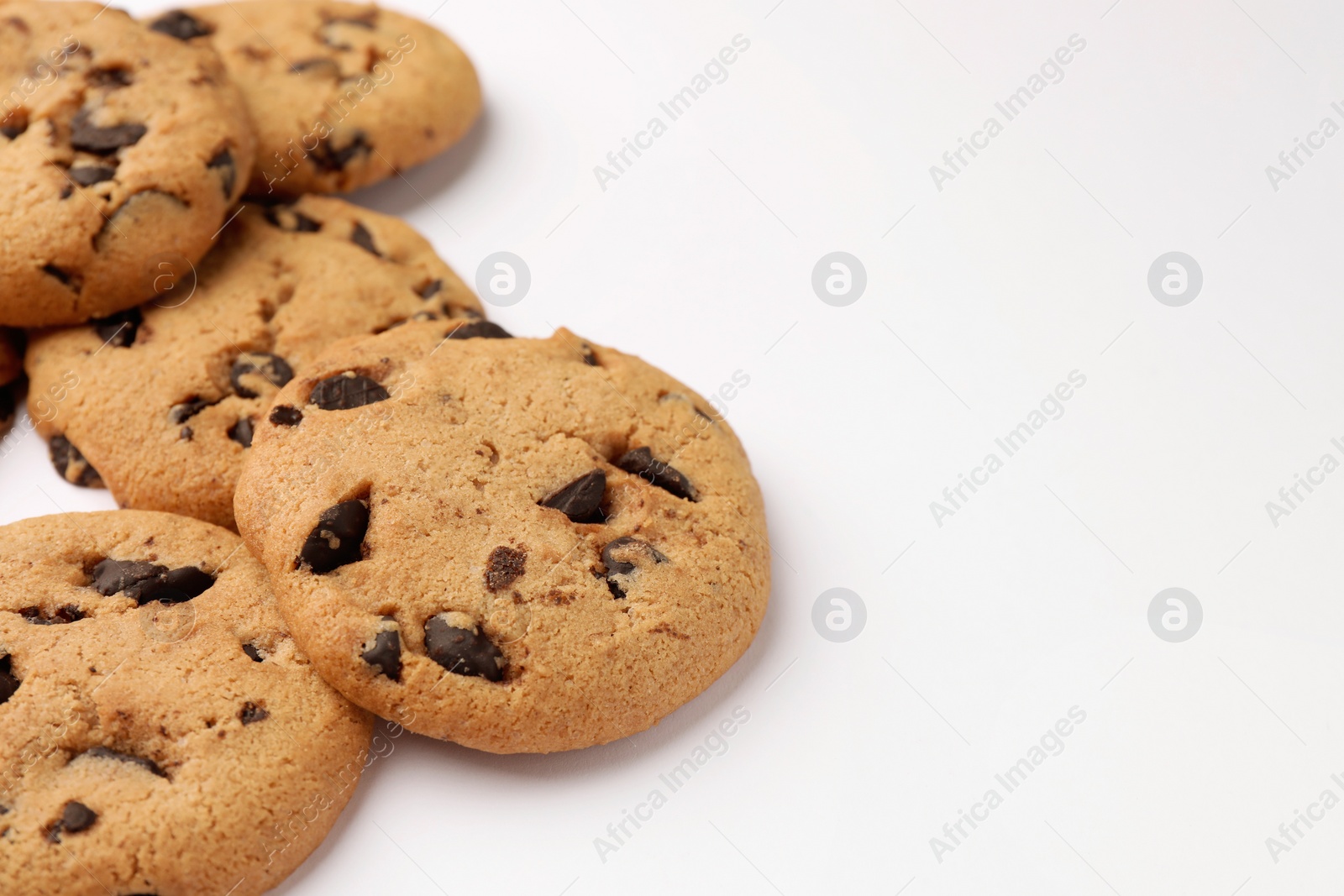 Photo of Delicious chocolate chip cookies on white background, closeup. Space for text