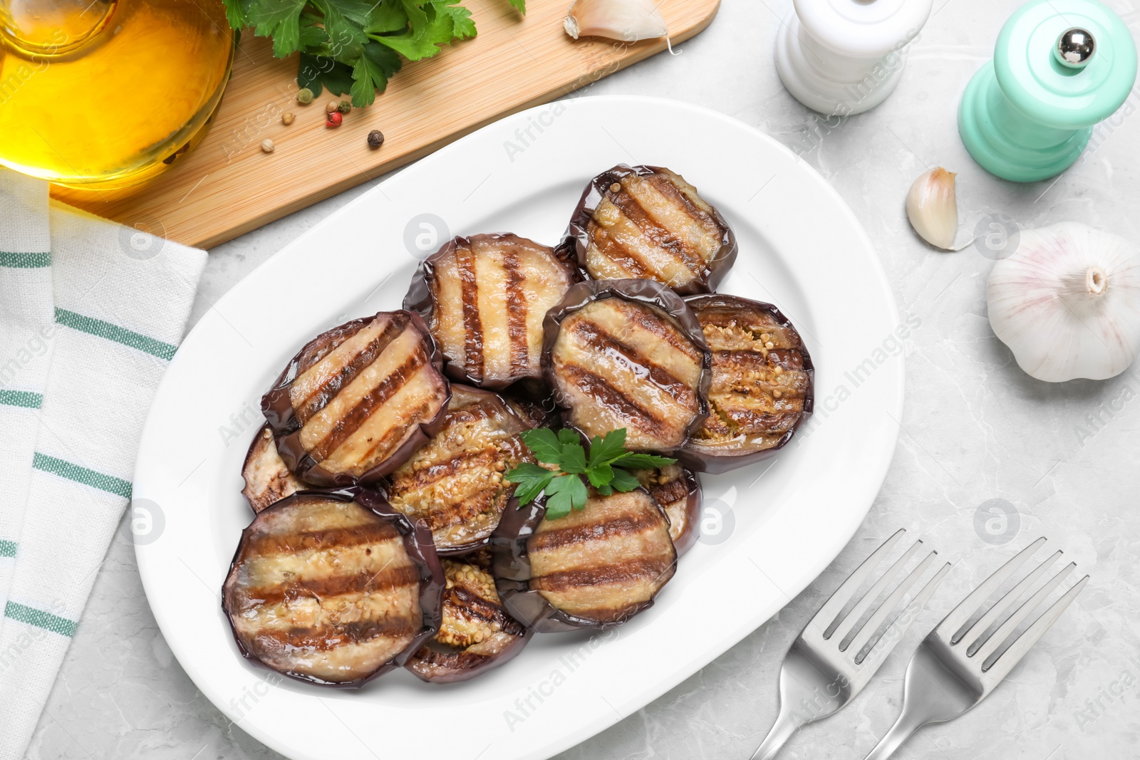Photo of Delicious grilled eggplant slices served on grey table, flat lay