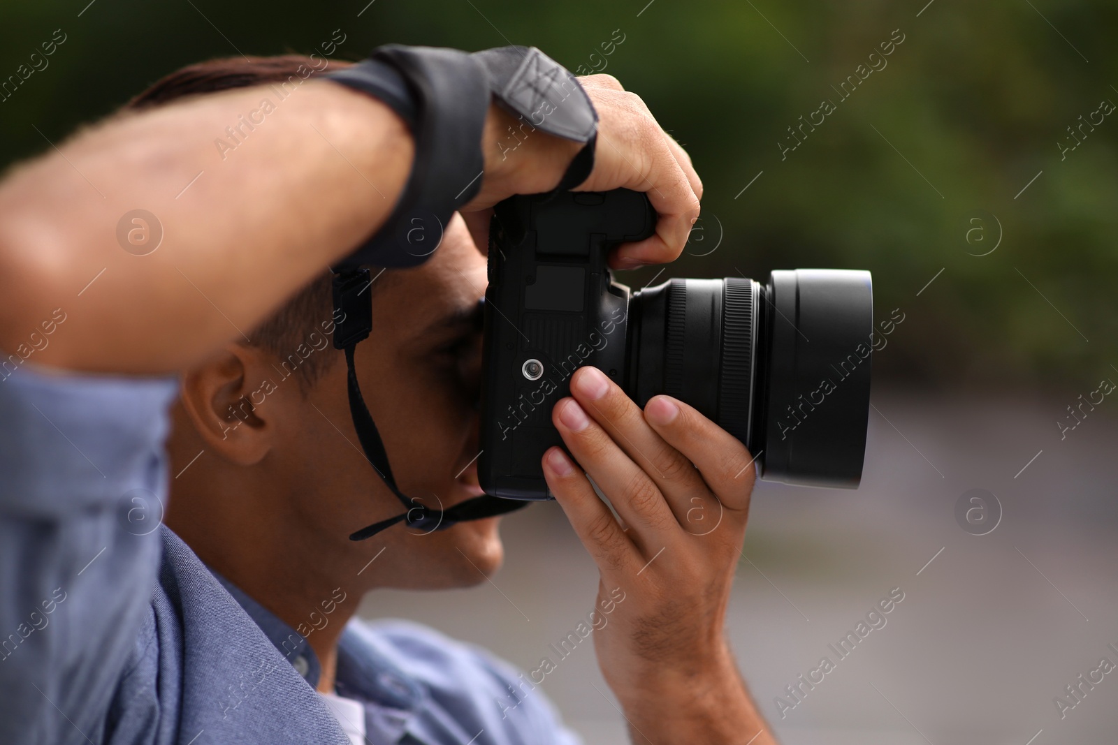 Photo of Photographer taking picture with professional camera outdoors, closeup