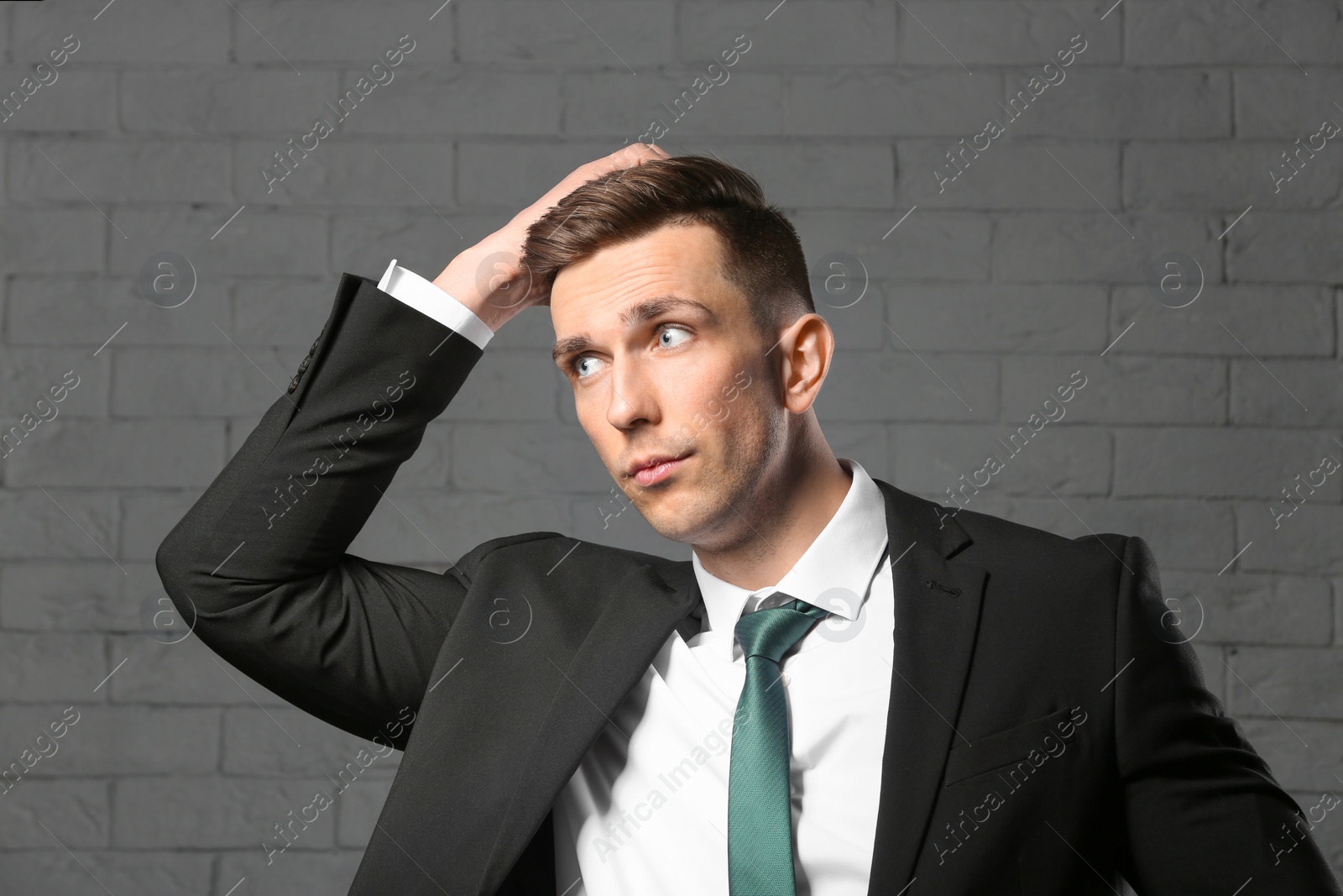 Photo of Portrait of young man with beautiful hair on brick wall background