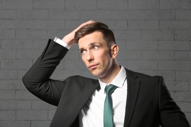 Portrait of young man with beautiful hair on brick wall background