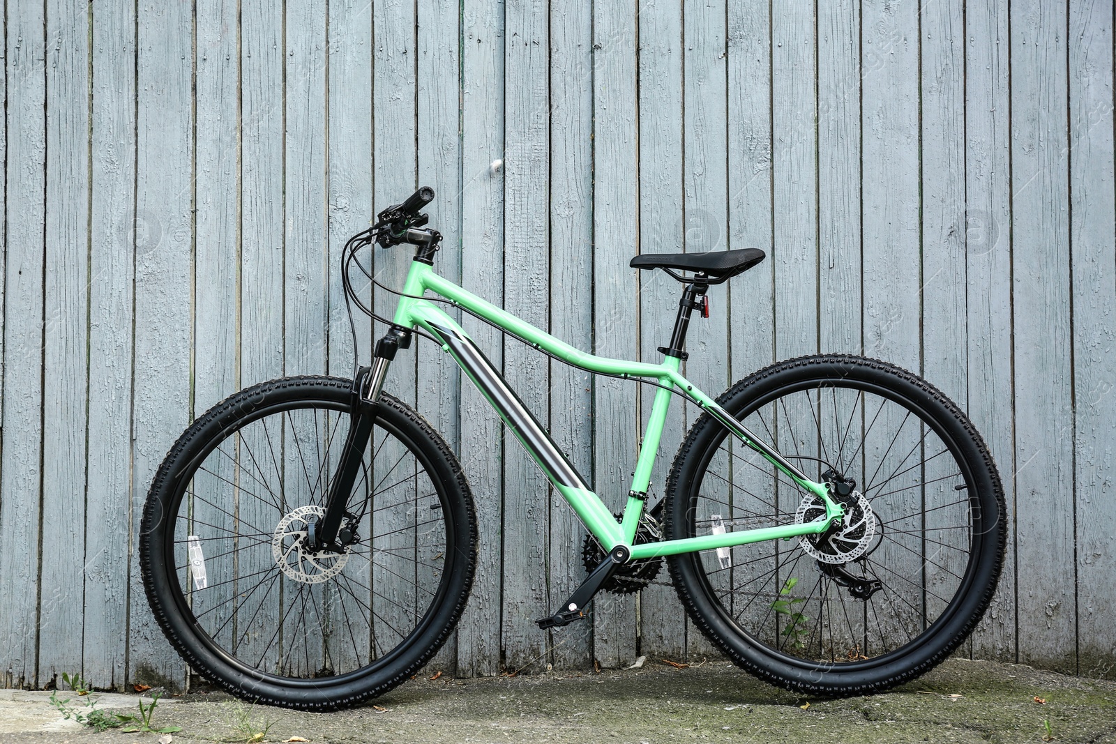 Photo of Modern bicycle near light wooden fence outdoors