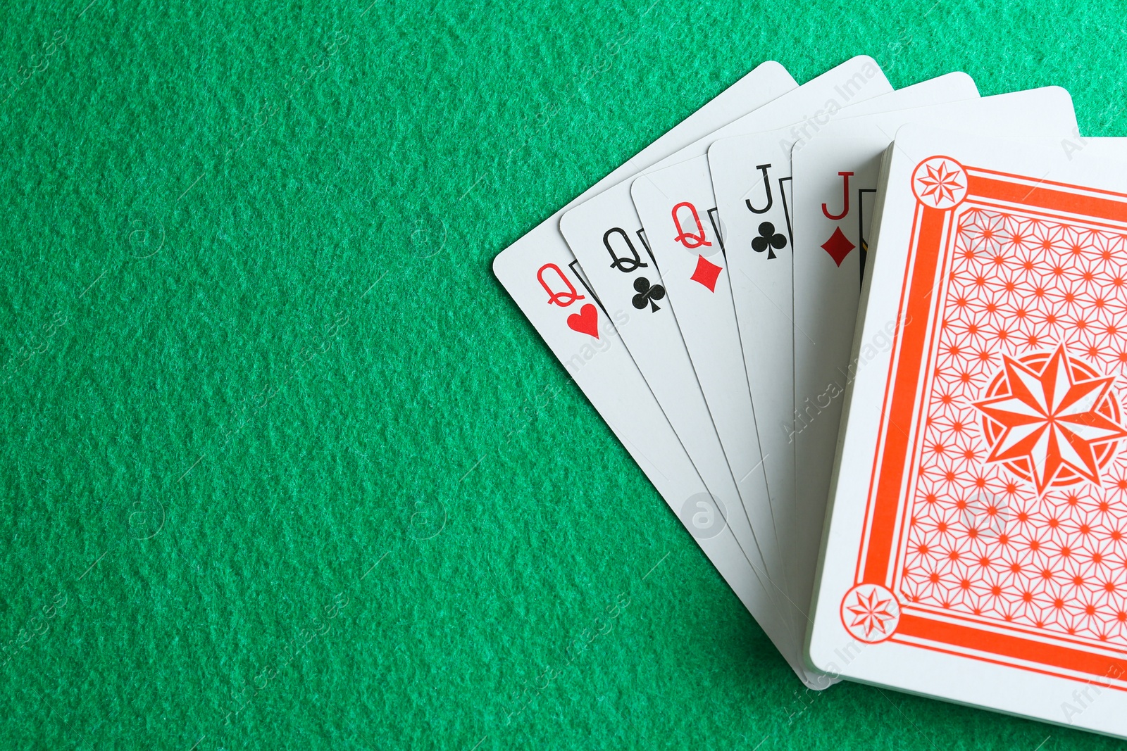 Photo of Playing cards with full house combination on green table, top view. Space for text