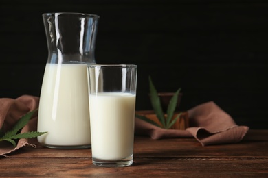 Photo of Glassware with hemp milk on wooden table