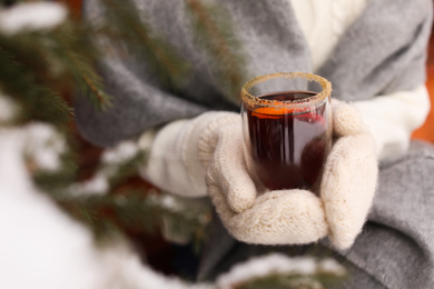 Photo of Woman with tasty mulled wine outdoors, closeup