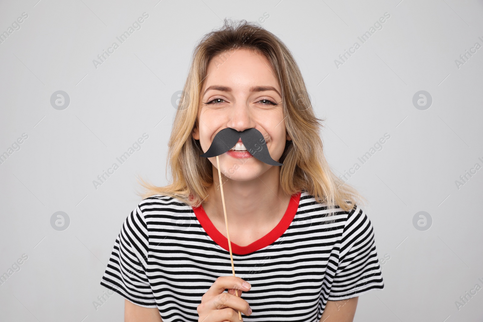 Photo of Funny woman with fake mustache on grey background