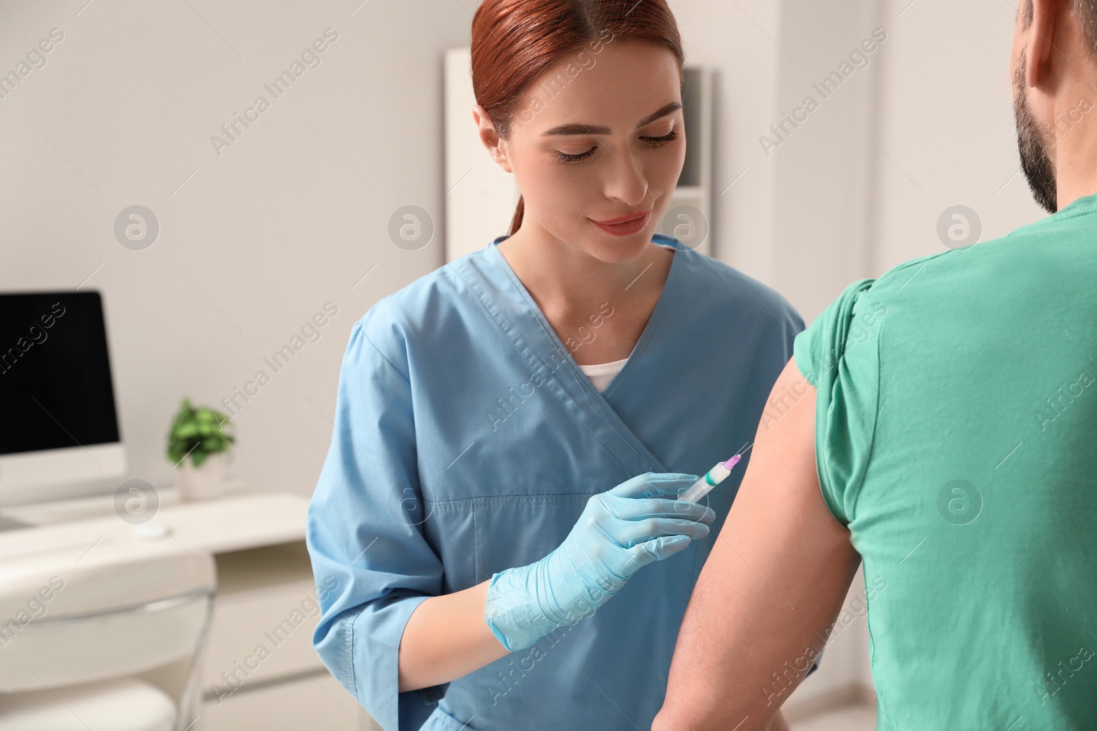 Photo of Doctor giving hepatitis vaccine to patient in clinic