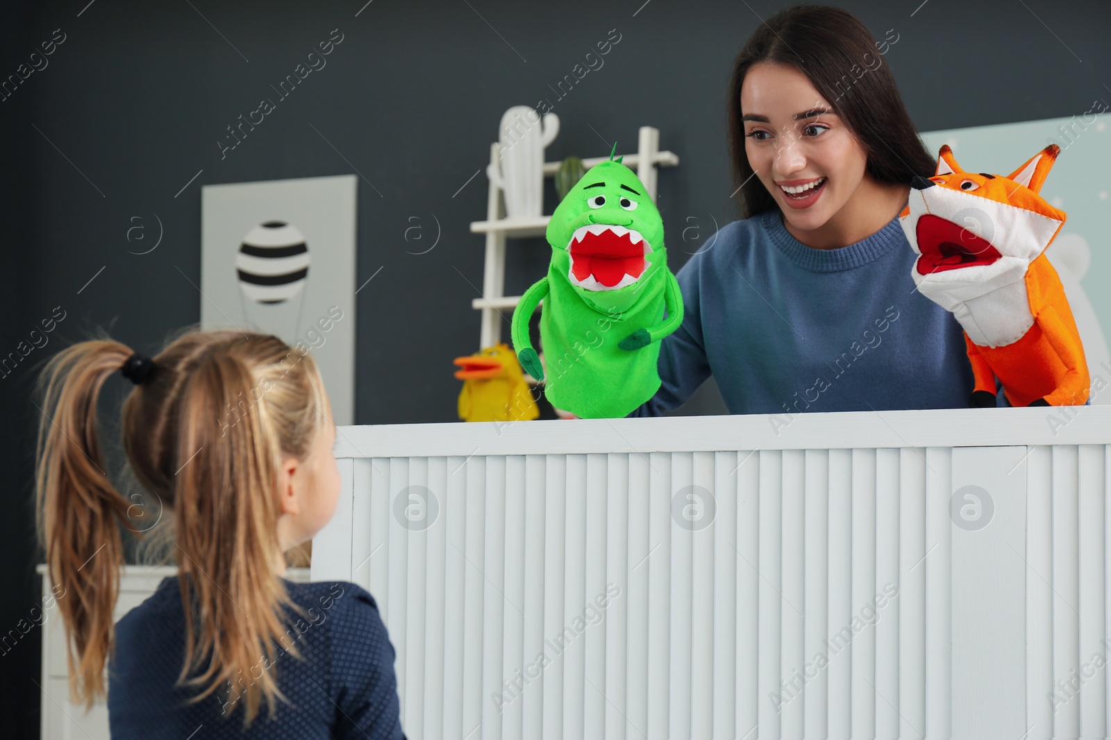 Photo of Mother performing puppet show for her daughter at home