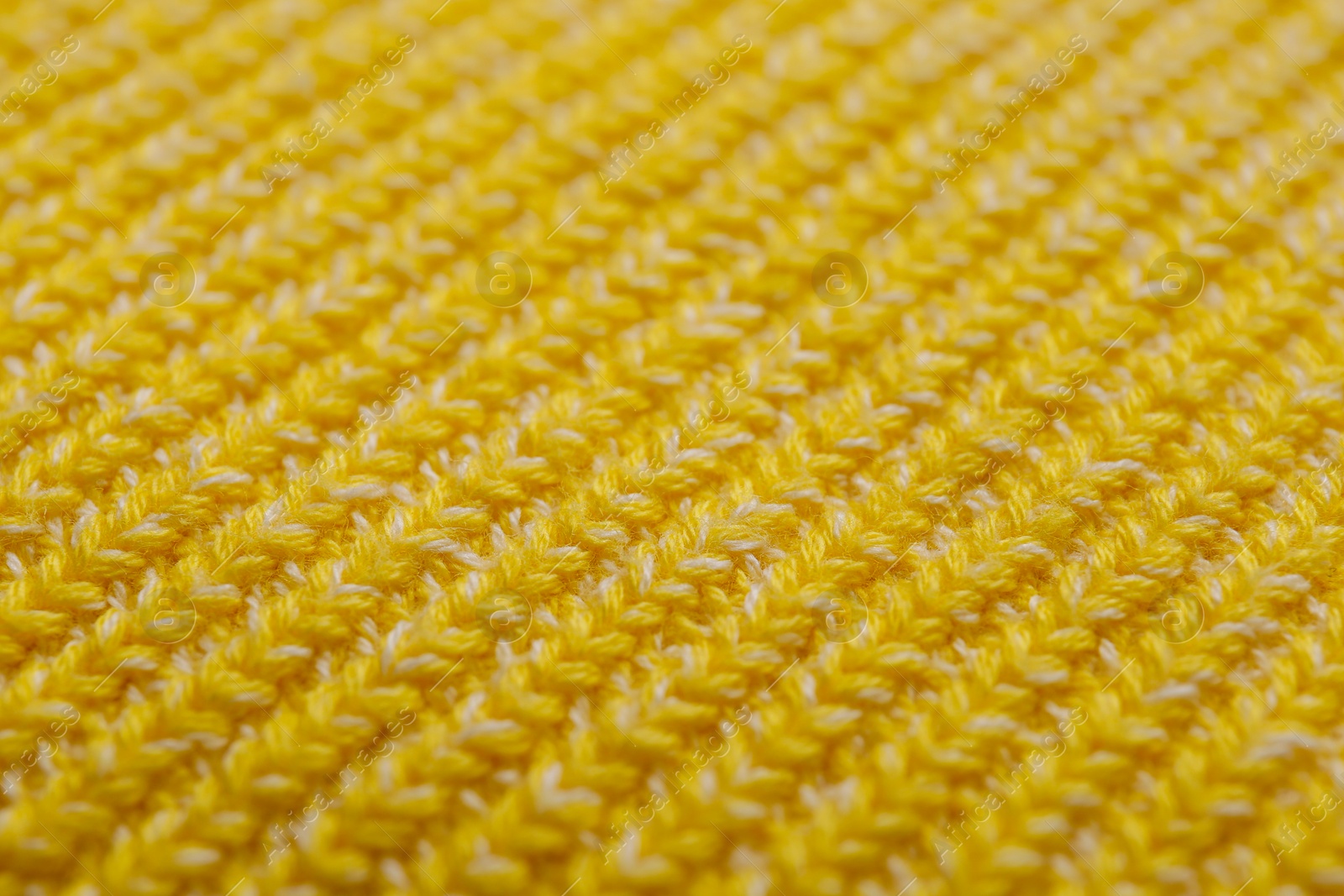 Photo of Yellow knitted fabric as background, closeup view