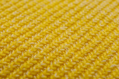 Photo of Yellow knitted fabric as background, closeup view