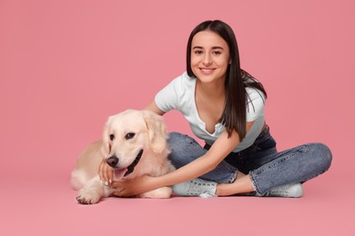 Photo of Happy woman with cute Labrador Retriever dog on pink background. Adorable pet