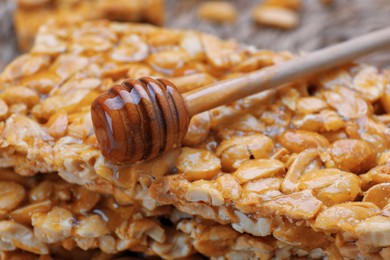Delicious peanut bars (kozinaki) and dipper with honey, closeup