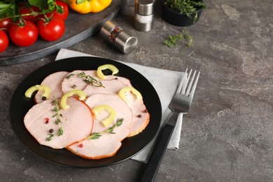 Photo of Delicious cut ham with thyme and bell pepper on grey table