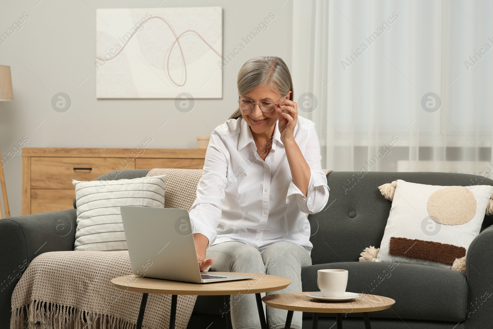 Photo of Beautiful senior woman using laptop at home