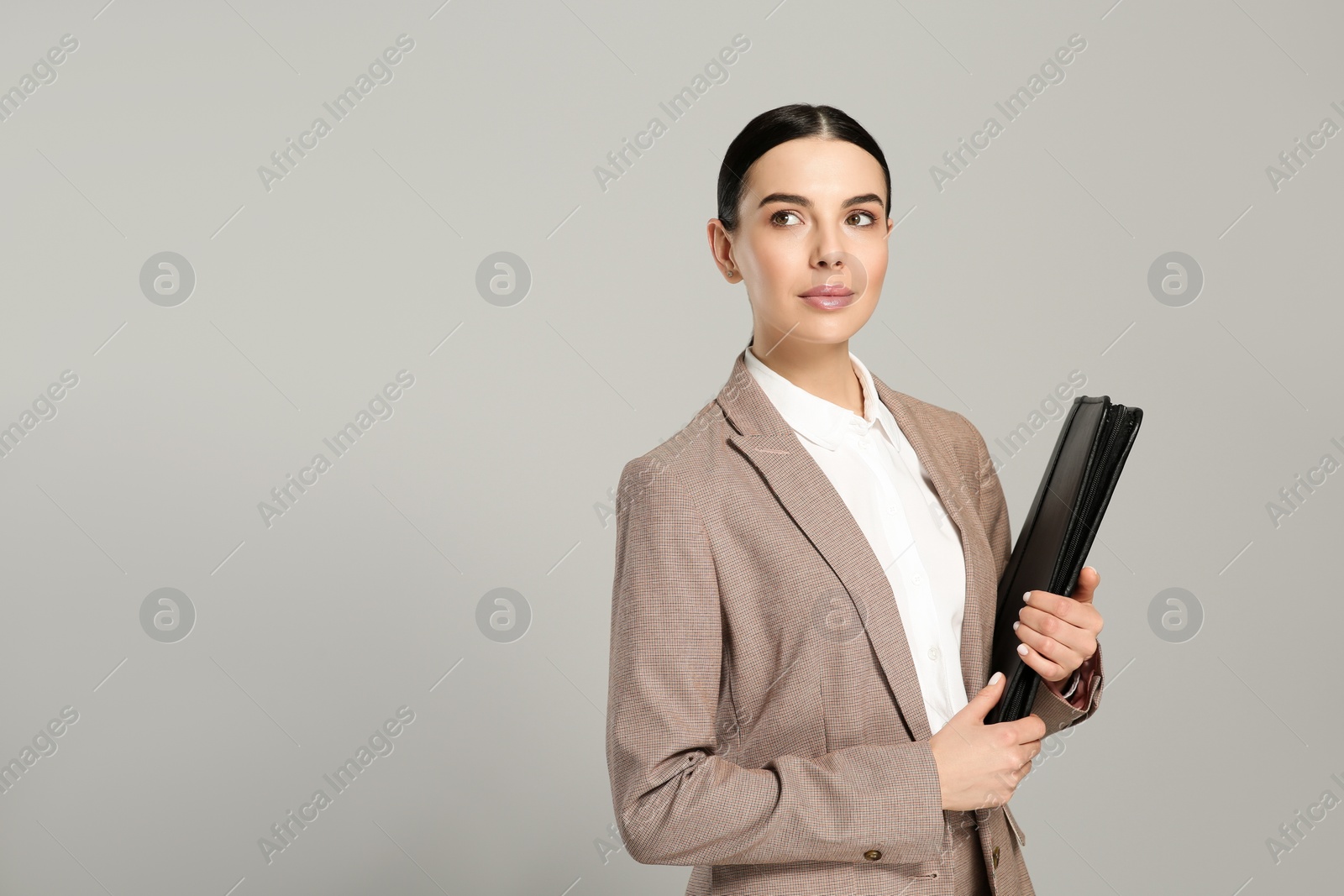 Photo of Beautiful real estate agent with documents on grey background. Space for text