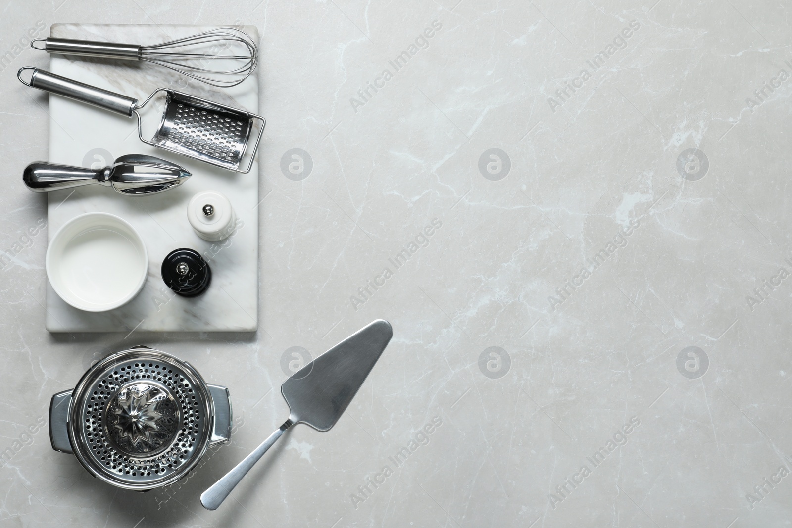 Photo of Set of different kitchen utensils on grey marble table, flat lay. Space for text