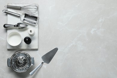 Photo of Set of different kitchen utensils on grey marble table, flat lay. Space for text