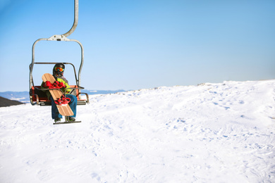 Photo of Man using chairlift at mountain ski resort, space for text. Winter vacation