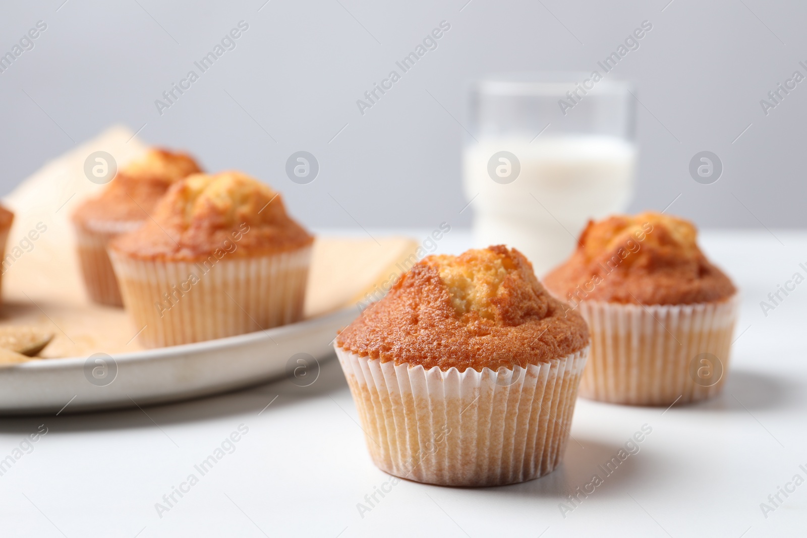 Photo of Delicious sweet muffins on white table, closeup. Space for text