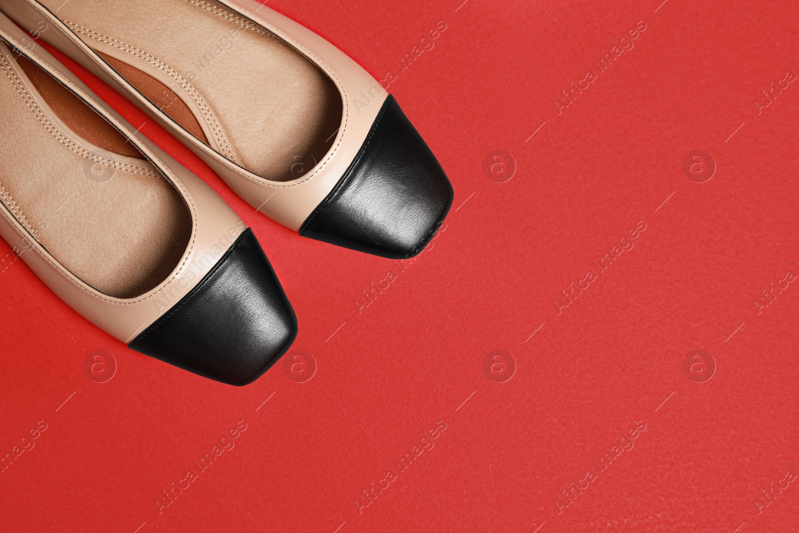 Photo of Pair of new stylish square toe ballet flats on red background, flat lay. Space for text