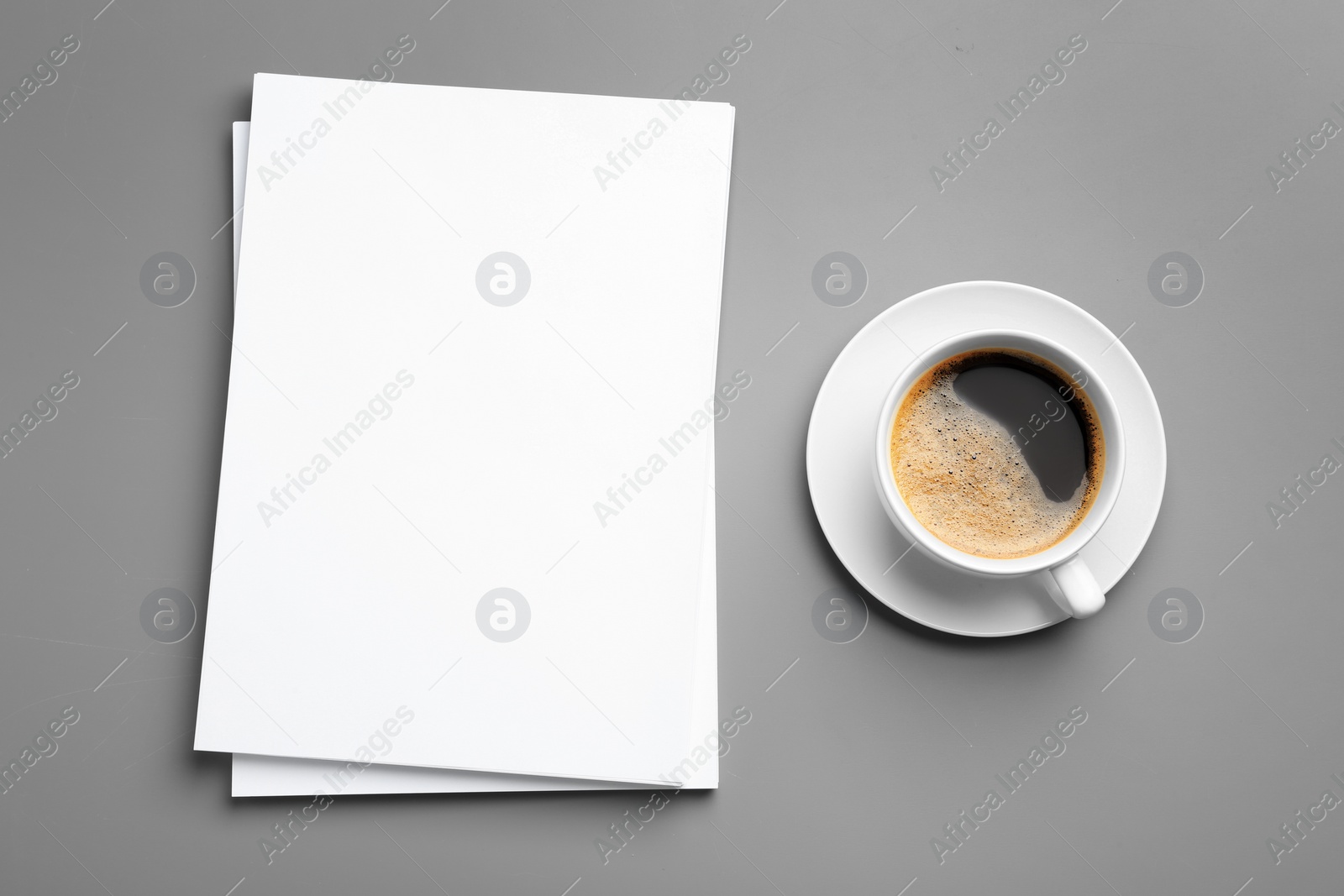 Photo of Blank paper sheets for brochure and cup of coffee on grey background, flat lay. Mock up