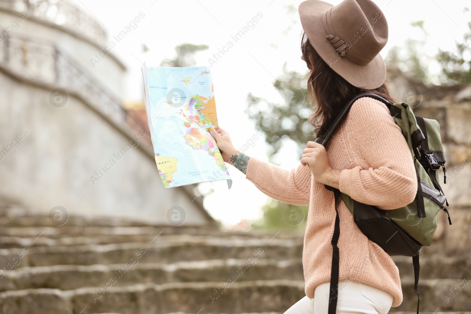 Photo of Traveler with map and backpack on city street