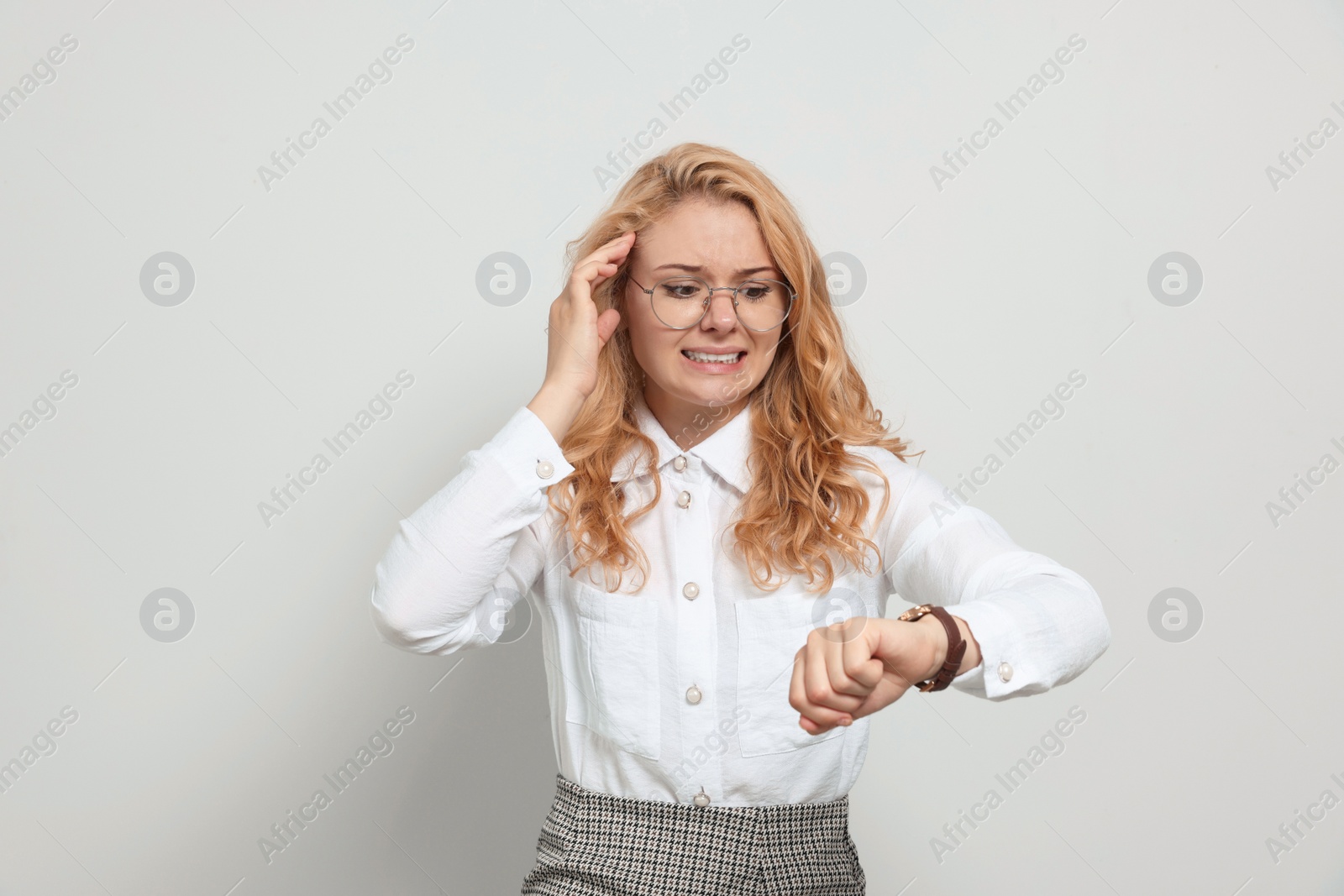 Photo of Emotional businesswoman in turmoil over being late on white background