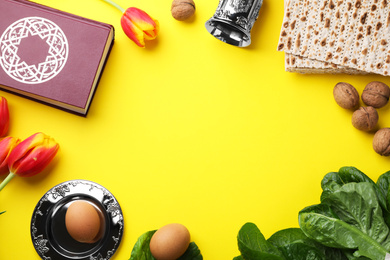 Flat lay composition with symbolic Pesach (Passover Seder) items on yellow background, space for text