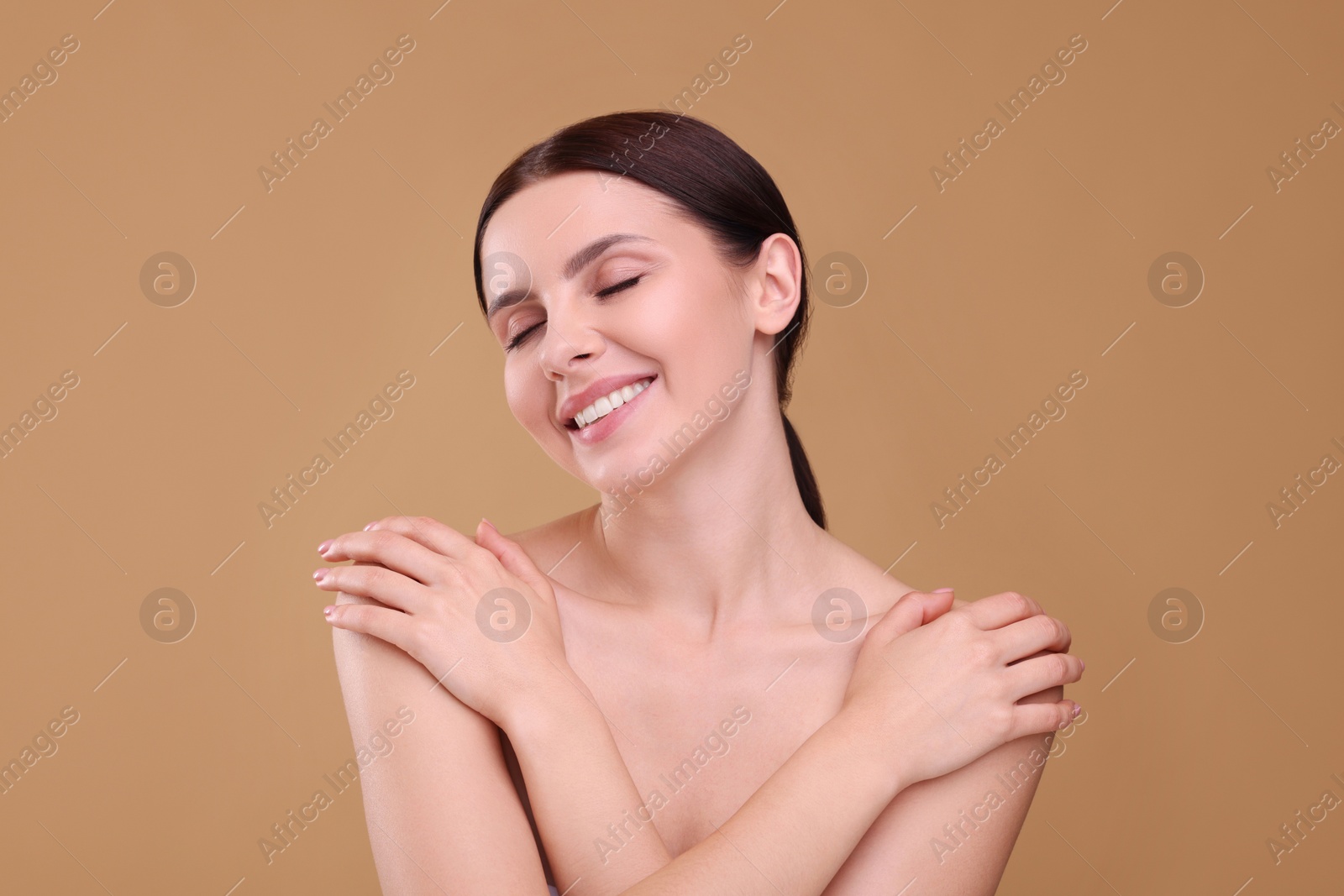 Photo of Beautiful woman with healthy skin on light brown background. Body Care