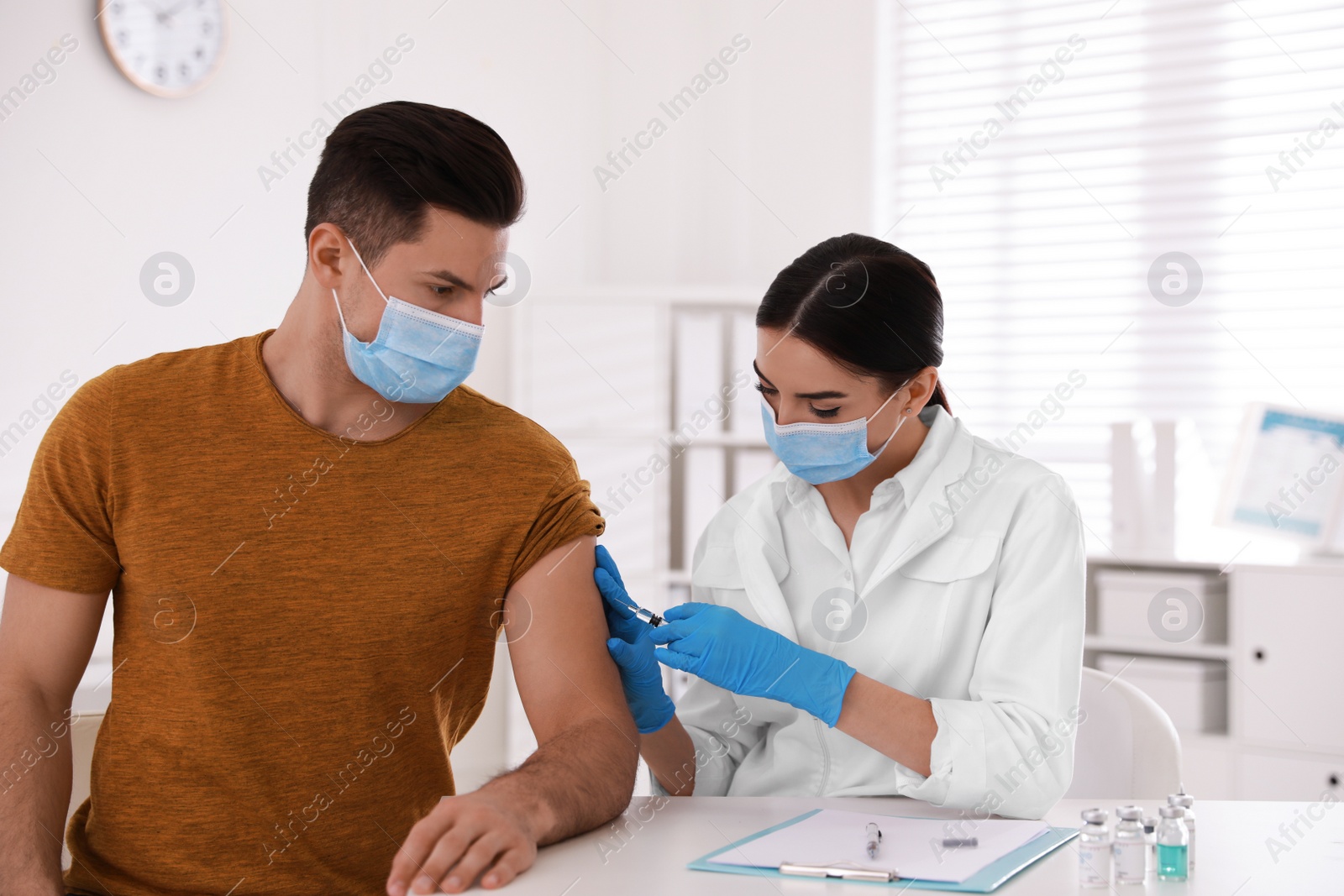 Photo of Doctor giving injection to patient in hospital. Vaccination campaign