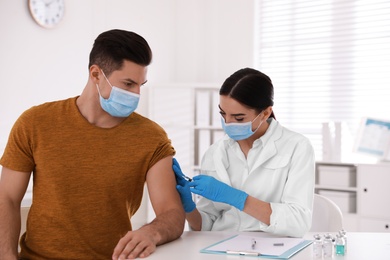 Doctor giving injection to patient in hospital. Vaccination campaign